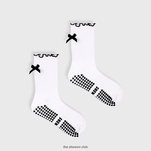 White Pilates crew grip socks with black ruffles and bow
